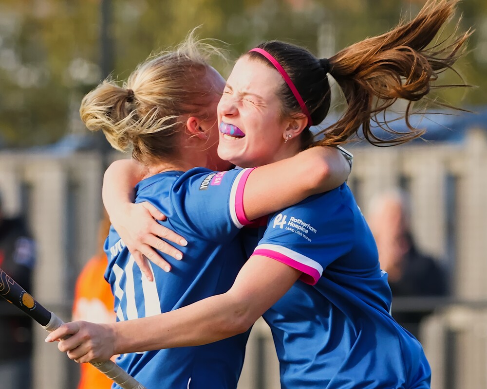 Two hockey players celebrate scoring a goal.