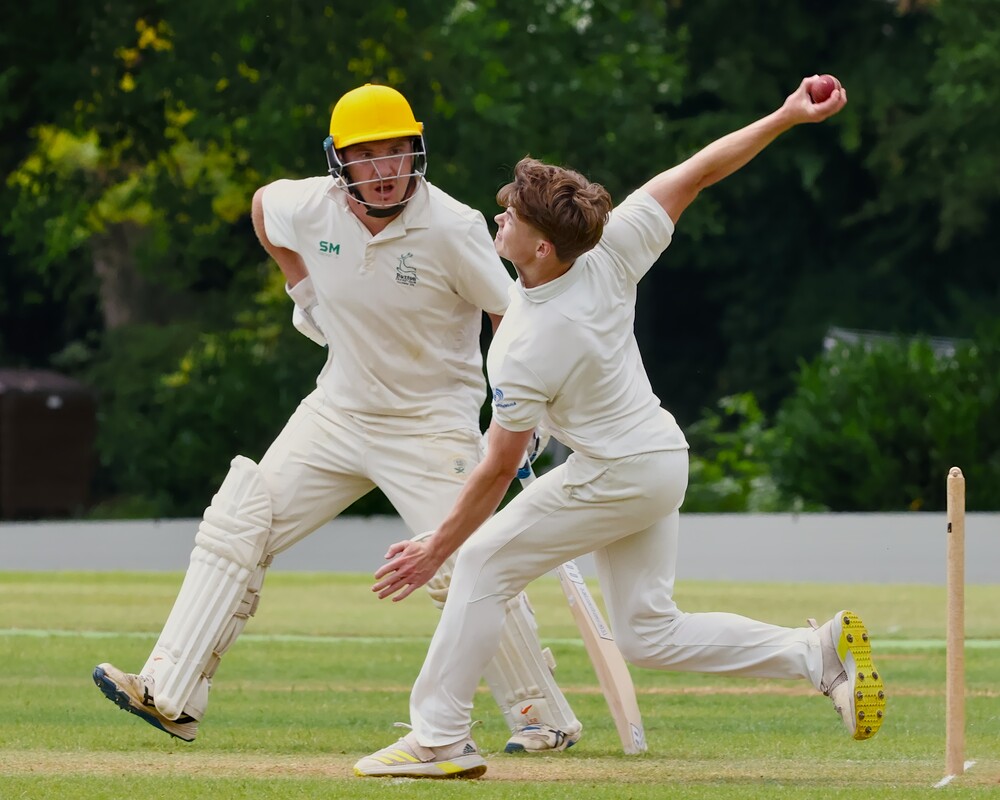 A batter watching a bowler during a cricket match.