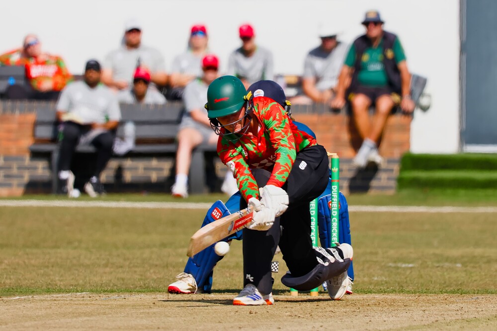 A cricketer hitting the ball.