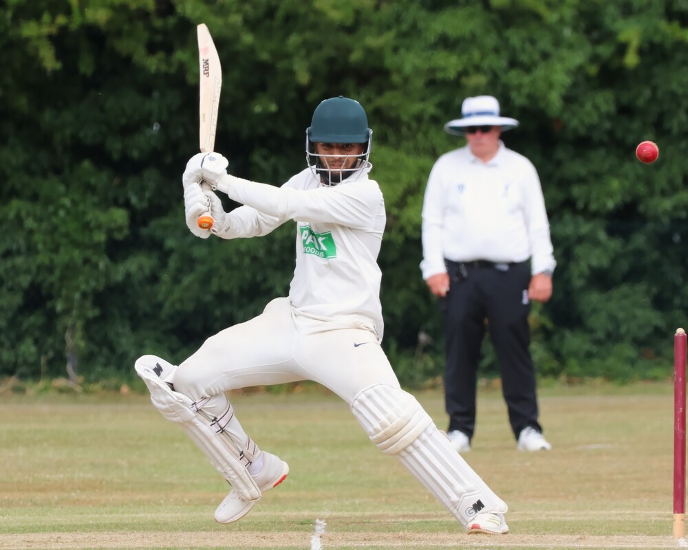 A cricketer hitting the ball.